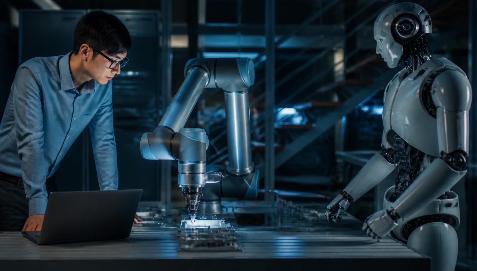 Engineer working alongside an industrial robotic arm and a humanoid robot in an AI research laboratory